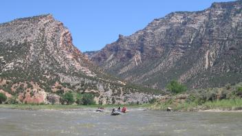 Rafting in open water in front of canyon